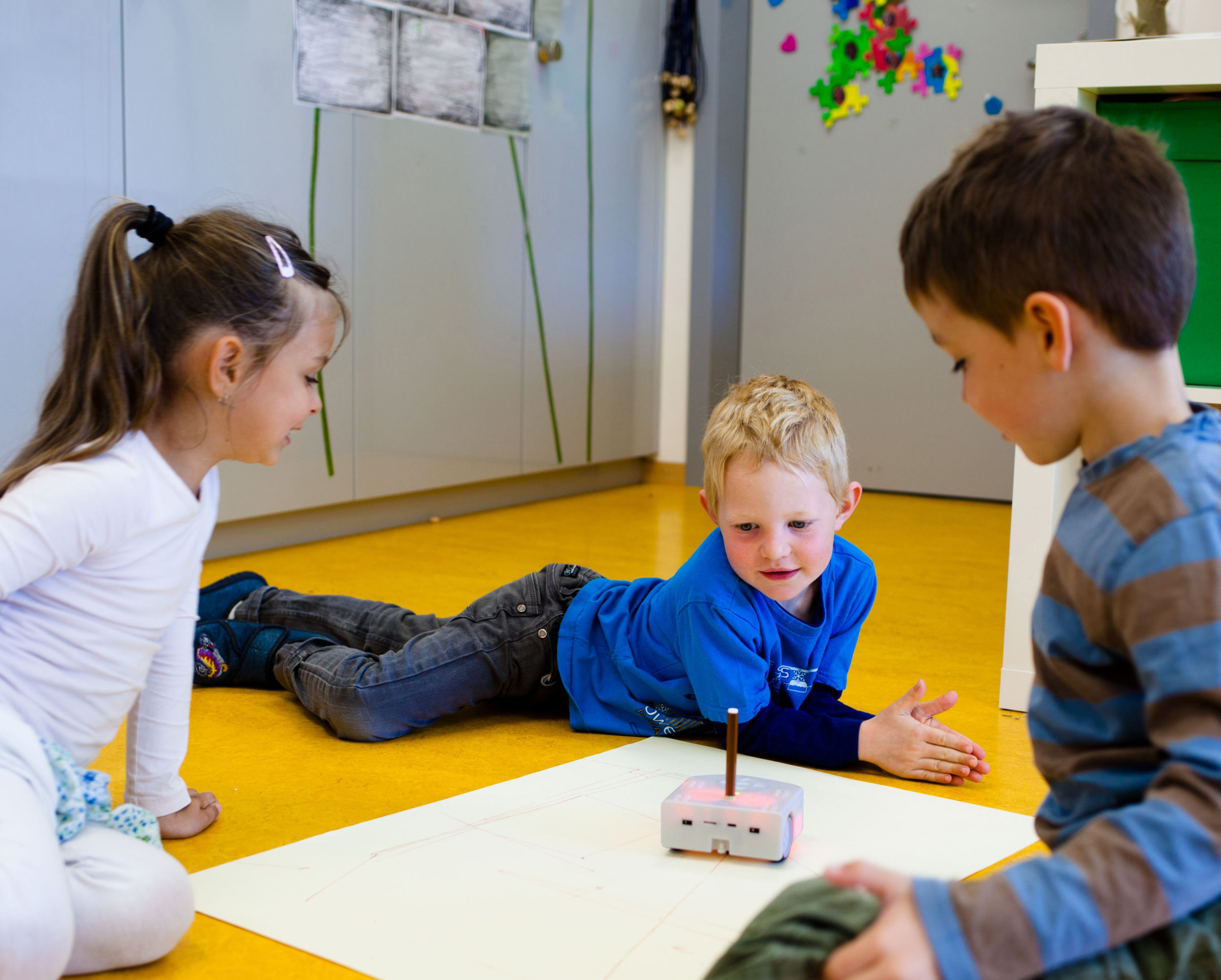 3 kids interact with the Thymio robot