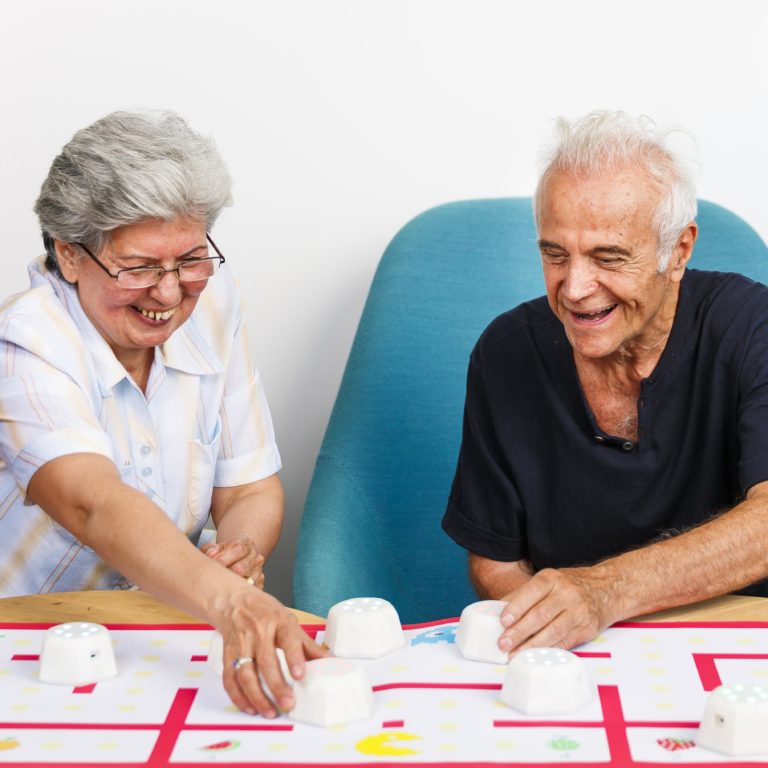 An older couple uses the Cellulo robot for rehab