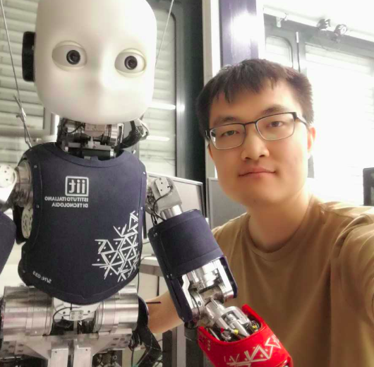 Photo of Anqing Duan with a robot