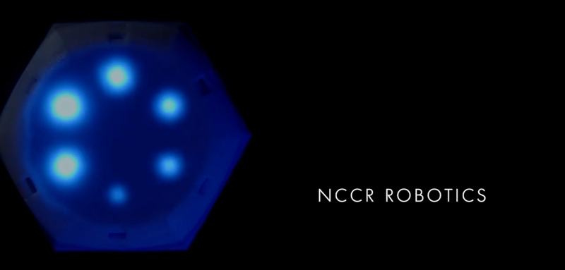 Photo of the Cellullo robot with some blue lights blinking on a black backgroud, with the title NCCR Robotics.